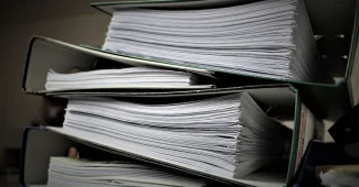 Dossiers administratifs et documents de politique familiale sur un bureau avec calculatrice