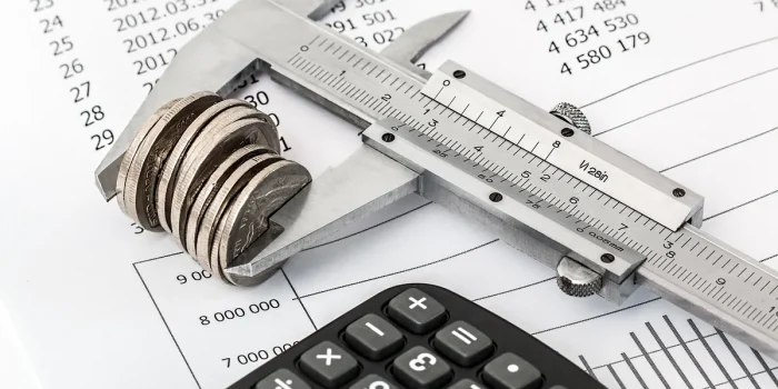 Bureau avec factures, relevés bancaires et écran affichant des tableaux de bord financiers
