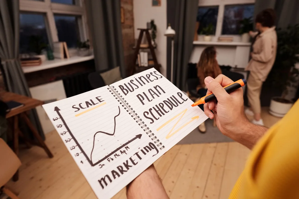 Entrepreneur planifiant sa stratégie d'entreprise avec cahier et calculs