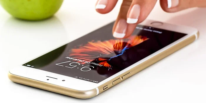 Mains tenant un smartphone affichant une notification de prime bancaire sur une application bancaire en ligne