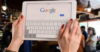 Développeur travaillant sur un ordinateur portable avec smartphone et tablette sur le bureau