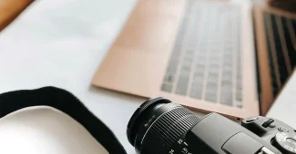 Bureau en journée avec ordinateur, factures et calculatrice illustrant la gestion des paiements internationaux