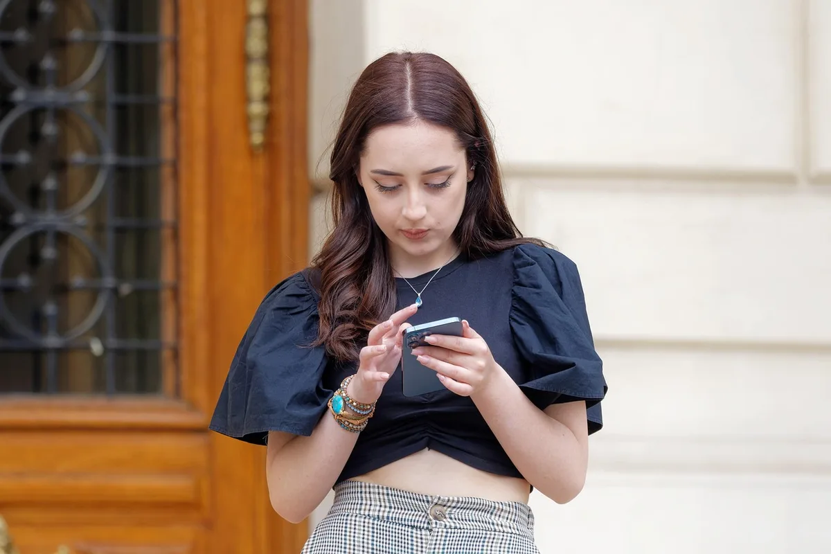 Personne vérifiant son application bancaire sur smartphone avant d'activer une offre