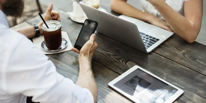 Mains anonymes autour d'une table de réunion avec dossiers et carnet