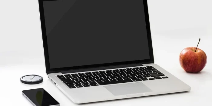 Bureau en lumière du jour avec ordinateur portable, plan de site imprimé et smartphone flou