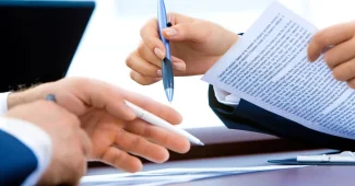 Bureau lumineux avec documents de création d'entreprise et mains d'un entrepreneur
