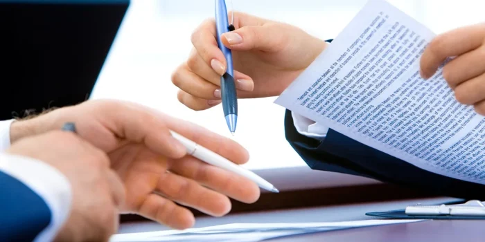 Bureau lumineux avec documents de création d'entreprise et mains d'un entrepreneur