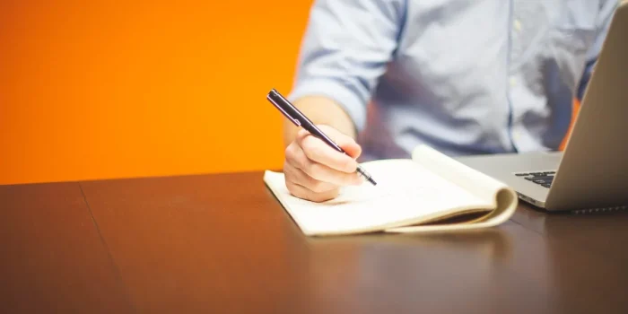 Mains anonymes triant de l'argent et des factures avec une calculatrice sur un bureau