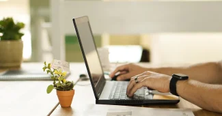 Bureau ensoleillé avec packs produits, feuille de règles promotionnelles et ordinateur portable