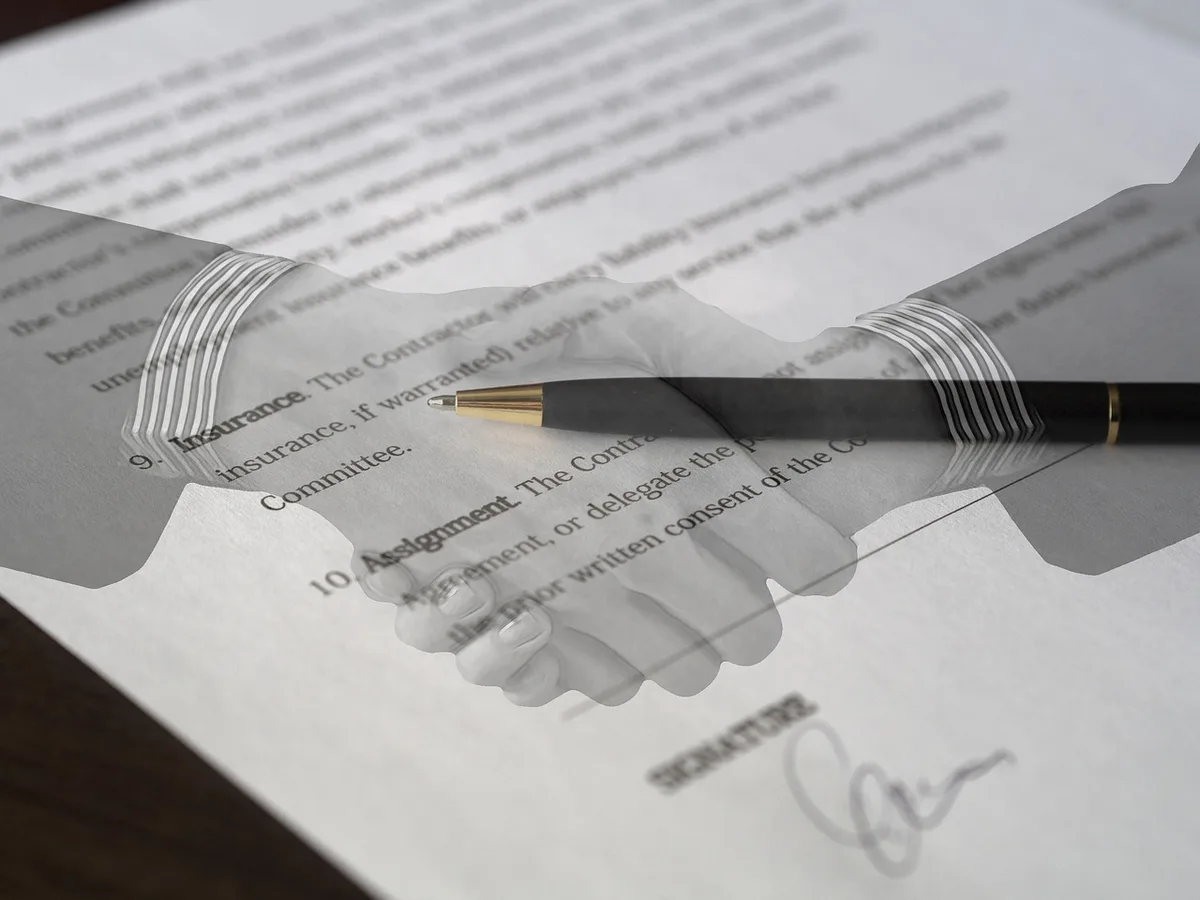 Deux personnes anonymes discutant autour de contrats et clauses statutaires