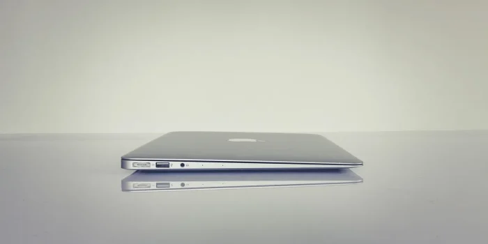 Mains anonymes sur une table avec documents d'entreprise et un ordinateur portable