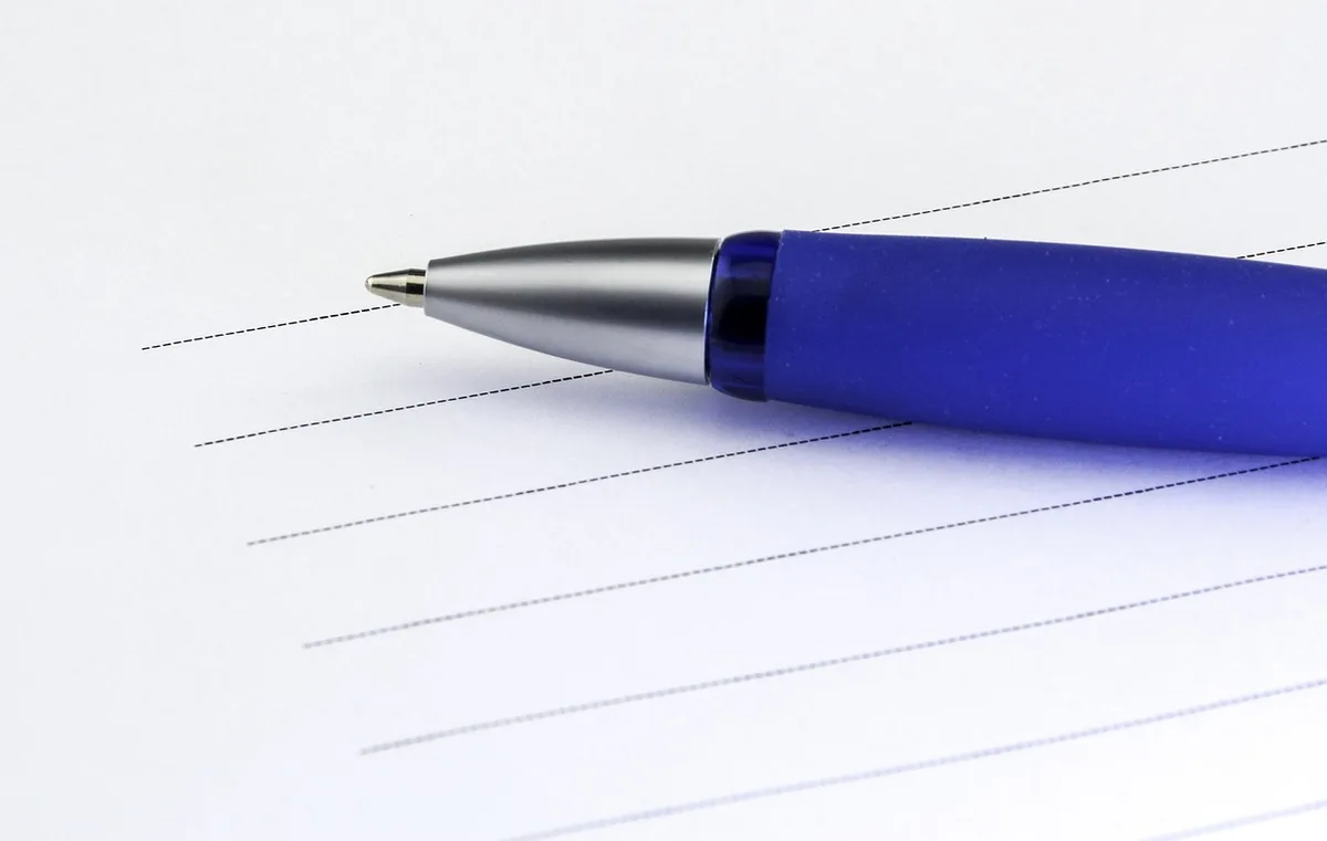 Liste d'avantages et d'inconvénients sur un carnet posé sur un bureau
