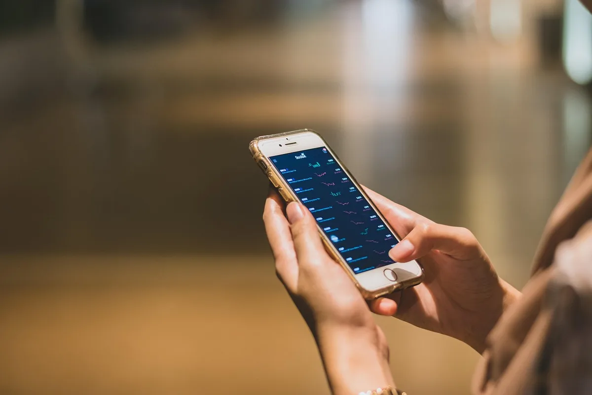 Personne tenant un smartphone affichant un flashcode pour paiement en ligne