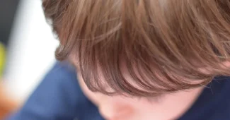 Parent examinant des documents de garde d'enfants et de calculs budgétaires à un bureau