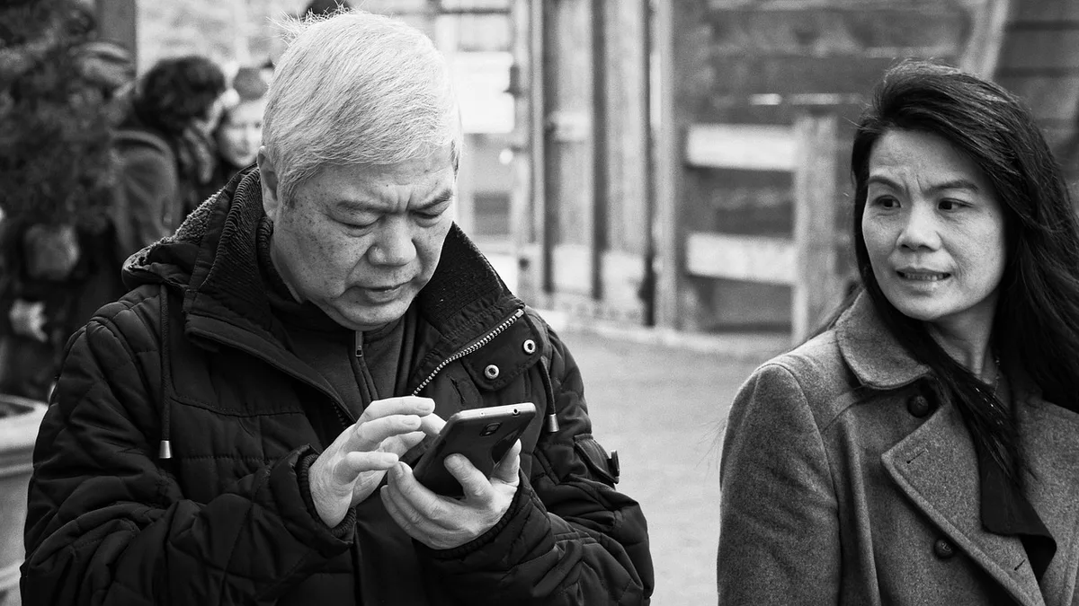 Main tenant un téléphone montrant un message texte suspect