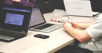 Personne anonyme vérifiant un bulletin de salaire et un contrat sur un bureau en plein jour