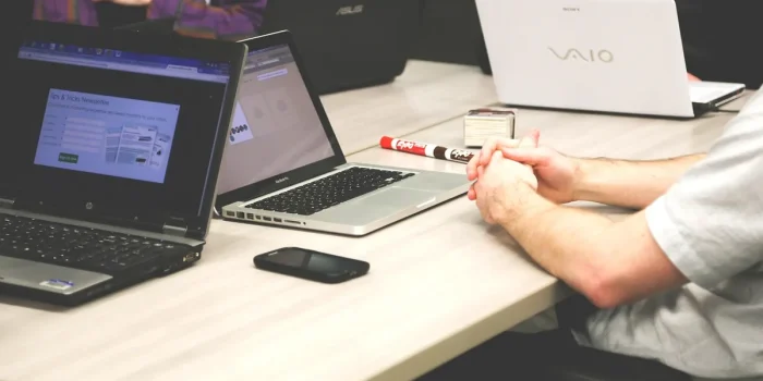 Personne anonyme vérifiant un bulletin de salaire et un contrat sur un bureau en plein jour