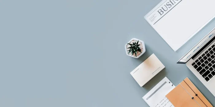 Bureau lumineux avec un carnet, une calculatrice et des mains notant des heures près d'une fenêtre en journée