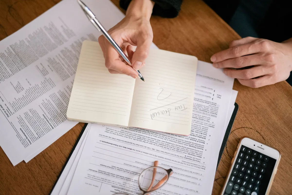 Personne examinant des documents financiers et une fiche précontractuelle