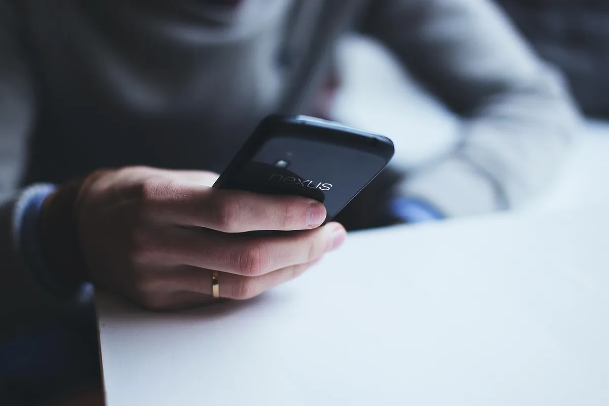 Écran de téléphone montrant une interface de virement bancaire en journée
