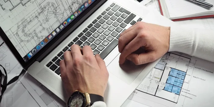Bureau lumineux avec ordinateur portable, mains anonymes et factures sur une table