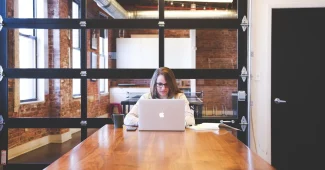 Pitch decks et calculatrice sur un bureau ensoleillé dans un espace de coworking