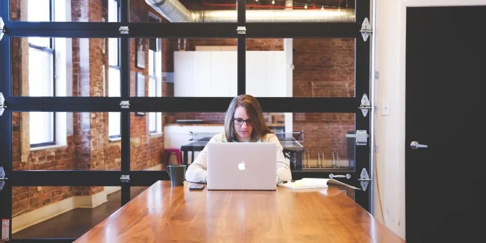 Pitch decks et calculatrice sur un bureau ensoleillé dans un espace de coworking