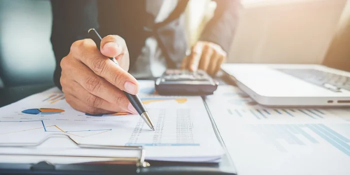 Bureau lumineux avec documents de PER et mains tenant une fiche de paie