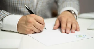Bureau en journée avec bulletin de paie, calculatrice et mains indiquant une ligne