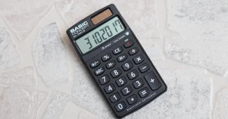 Bulletin de salaire et calculatrice sur un bureau ensoleillé